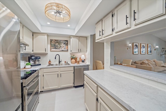 1211 Capri Isles Blvd Unit 6, Venice, FL 34292 - kitchen with appliances with stainless steel finishes, light countertops, under cabinet range hood, recessed lighting, and white cabinetry