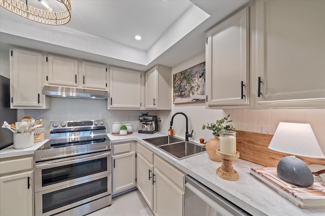 1211 Capri Isles Blvd Unit 6, Venice, FL 34292 - kitchen with range with two ovens, under cabinet range hood, light countertops, decorative backsplash, and recessed lighting