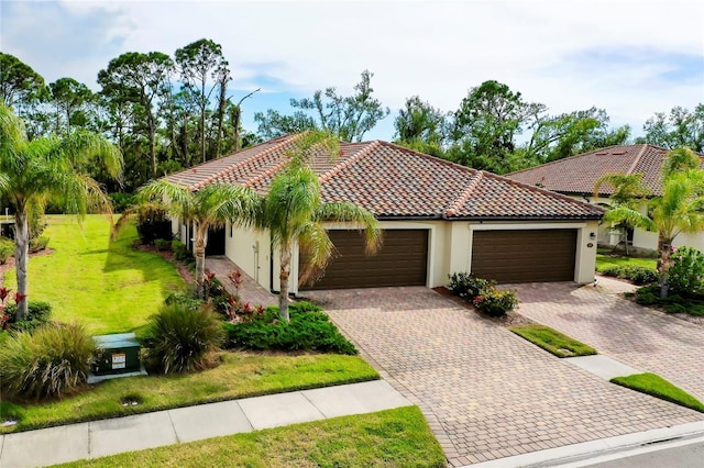 12187 Amica Loop, Venice, FL 34293 - mediterranean / spanish-style home with stucco siding, a garage, a front yard, driveway, and a tile roof