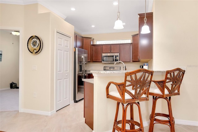 12187 Amica Loop, Venice, FL 34293 - kitchen featuring appliances with stainless steel finishes, a peninsula, light countertops, a kitchen breakfast bar, and pendant lighting
