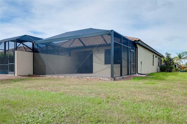 12187 Amica Loop, Venice, FL 34293 - rear view of property with a lanai, stucco siding, a lawn, and a tile roof