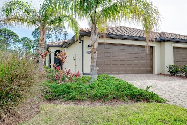 12187 Amica Loop, Venice, FL 34293 - view of front facade featuring stucco siding, a tiled roof, decorative driveway, and an attached garage