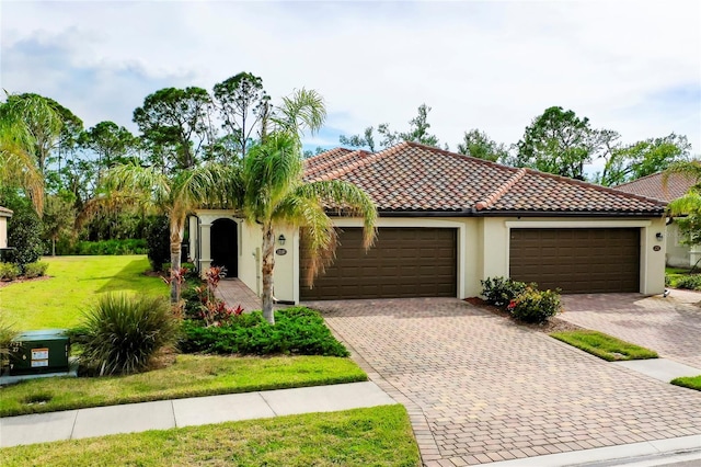 12187 Amica Loop, Venice, FL 34293 - mediterranean / spanish-style house featuring an attached garage, driveway, stucco siding, and a front lawn