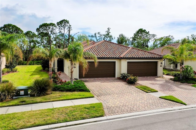 12187 Amica Loop, Venice, FL 34293 - mediterranean / spanish-style house featuring stucco siding, an attached garage, a front lawn, driveway, and a tiled roof
