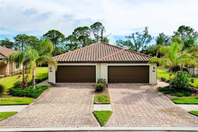 12187 Amica Loop, Venice, FL 34293 - mediterranean / spanish-style house featuring stucco siding, driveway, a tile roof, and an attached garage