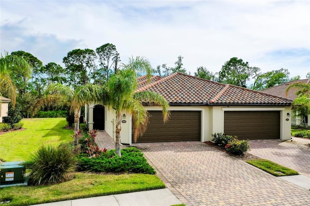 12187 Amica Loop, Venice, FL 34293 - mediterranean / spanish home with decorative driveway, an attached garage, and stucco siding