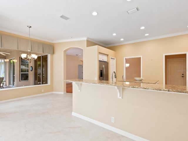 355 Swallow Cir, Venice, FL 34285 - kitchen with stainless steel fridge with ice dispenser, ornamental molding, a kitchen breakfast bar, arched walkways, and recessed lighting
