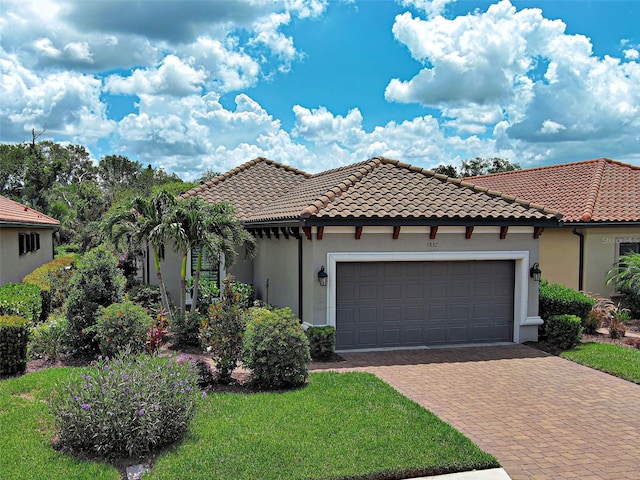 5832 Semolino St, Nokomis, FL 34275 - mediterranean / spanish-style house featuring stucco siding, a garage, decorative driveway, a front lawn, and a tile roof