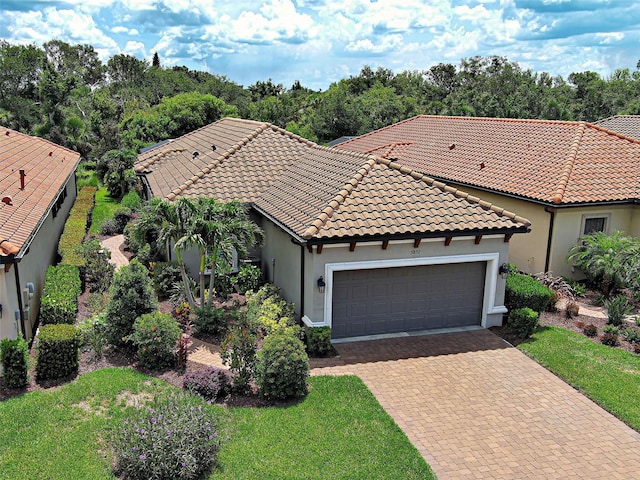 5832 Semolino St, Nokomis, FL 34275 - mediterranean / spanish house with an attached garage, decorative driveway, stucco siding, and a tiled roof