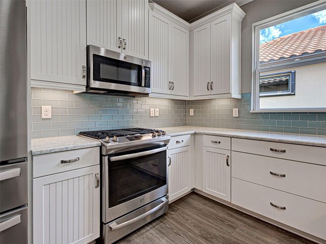 5832 Semolino St, Nokomis, FL 34275 - kitchen with stainless steel appliances, white cabinets, backsplash, and dark wood-style flooring