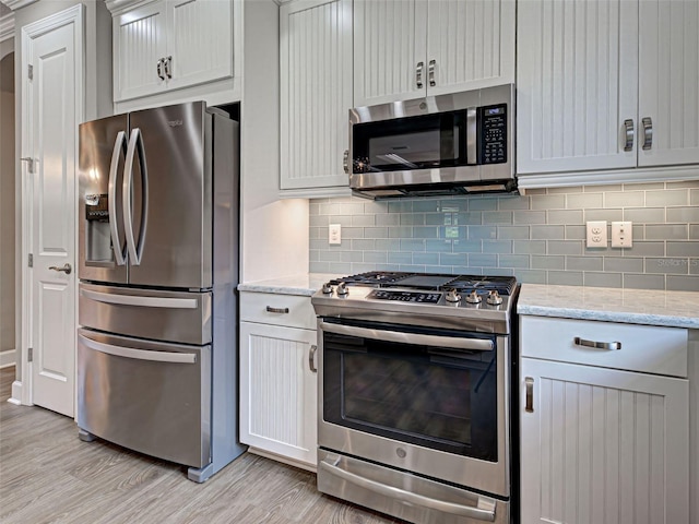 5832 Semolino St, Nokomis, FL 34275 - kitchen with appliances with stainless steel finishes, light wood finished floors, tasteful backsplash, and light stone counters