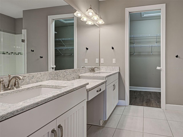 5832 Semolino St, Nokomis, FL 34275 - bathroom with double vanity, a walk in closet, tiled shower, and tile patterned floors