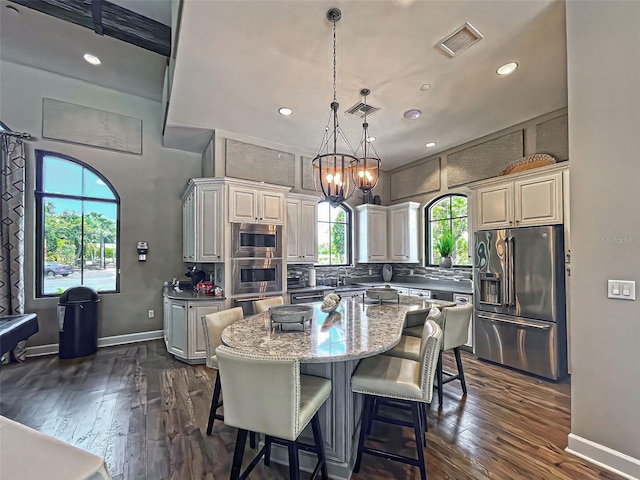 5832 Semolino St, Nokomis, FL 34275 - kitchen with appliances with stainless steel finishes, dark wood-type flooring, a kitchen island, decorative backsplash, and recessed lighting