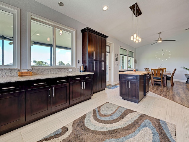 48 Lark Dr, Placida, FL 33946 - kitchen featuring hanging light fixtures, dark brown cabinetry, light stone countertops, a ceiling fan, and recessed lighting