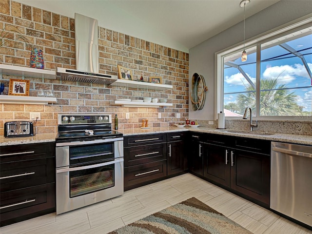 48 Lark Dr, Placida, FL 33946 - kitchen with stainless steel appliances, wall chimney range hood, open shelves, light stone countertops, and vaulted ceiling
