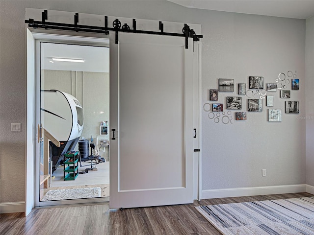 48 Lark Dr, Placida, FL 33946 - entryway with a barn door, wood finished floors, and a textured wall