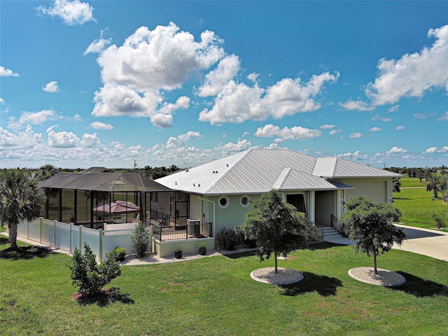 48 Lark Dr, Placida, FL 33946 - rear view of house featuring a lawn, an attached garage, a lanai, concrete driveway, and a metal roof