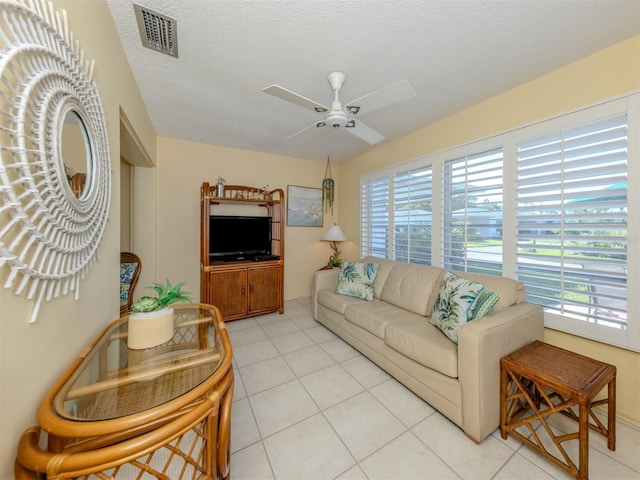 168 The Corso Unit 168, Venice, FL 34285 - living room with healthy amount of natural light, ceiling fan, light tile patterned floors, and a textured ceiling