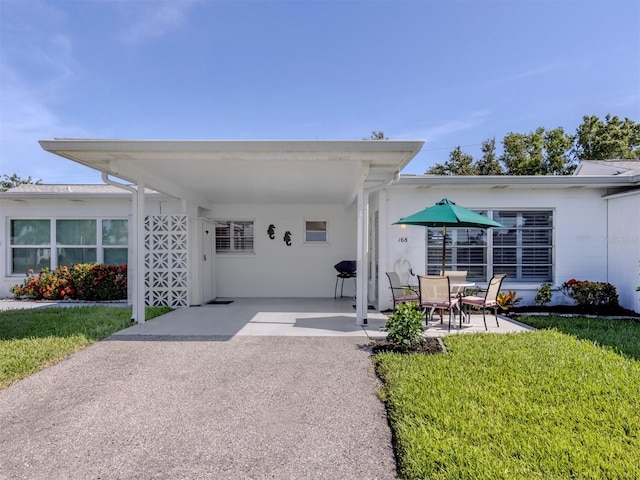 168 The Corso Unit 168, Venice, FL 34285 - back of house featuring a yard and a carport