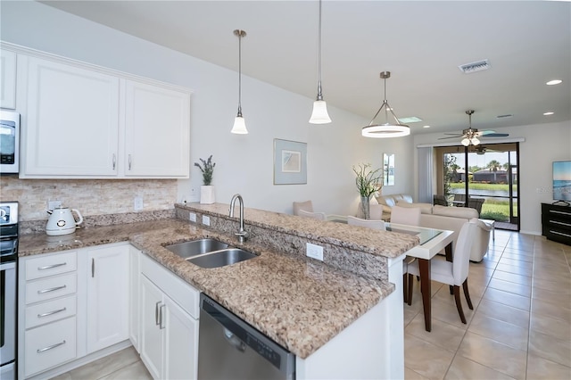 19269 Serafina St, Venice, FL 34293 - kitchen featuring stainless steel dishwasher, light tile patterned flooring, open floor plan, decorative backsplash, and white cabinetry