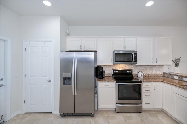 19269 Serafina St, Venice, FL 34293 - kitchen featuring appliances with stainless steel finishes, white cabinets, light stone countertops, backsplash, and light tile patterned flooring