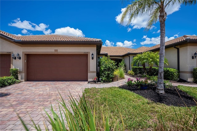 19269 Serafina St, Venice, FL 34293 - view of front of house featuring a tiled roof, stucco siding, an attached garage, and decorative driveway