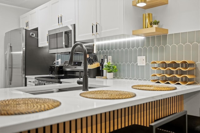 437 Cerromar Ln Unit 424, Venice, FL 34293 - kitchen with appliances with stainless steel finishes, tasteful backsplash, light countertops, and white cabinets