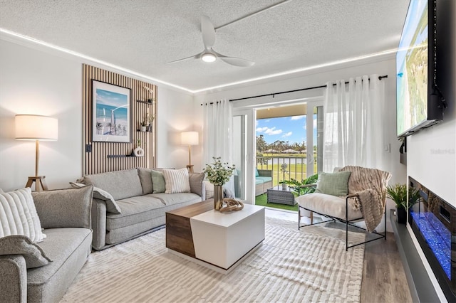 437 Cerromar Ln Unit 424, Venice, FL 34293 - living room featuring a textured ceiling, wood finished floors, ceiling fan, and a fireplace