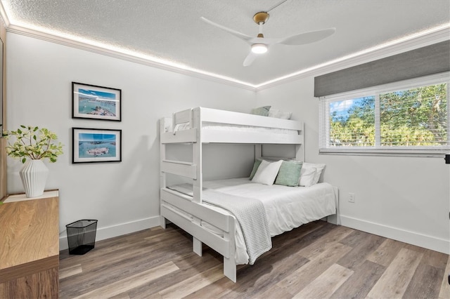 437 Cerromar Ln Unit 424, Venice, FL 34293 - bedroom with a textured ceiling, wood finished floors, crown molding, and ceiling fan