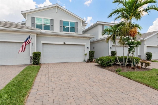 935 Tidewater Shrs Unit 721, Bradenton, FL 34208 - traditional home featuring decorative driveway, a tiled roof, stucco siding, and an attached garage