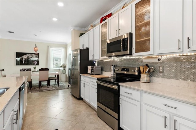 935 Tidewater Shrs Unit 721, Bradenton, FL 34208 - kitchen featuring stainless steel appliances, ornamental molding, decorative backsplash, white cabinetry, and recessed lighting