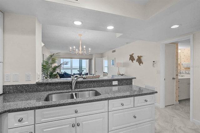 950 Tarpon Center Dr Unit 305, Venice, FL 34285 - kitchen with white cabinetry, dark stone countertops, a chandelier, a peninsula, and recessed lighting