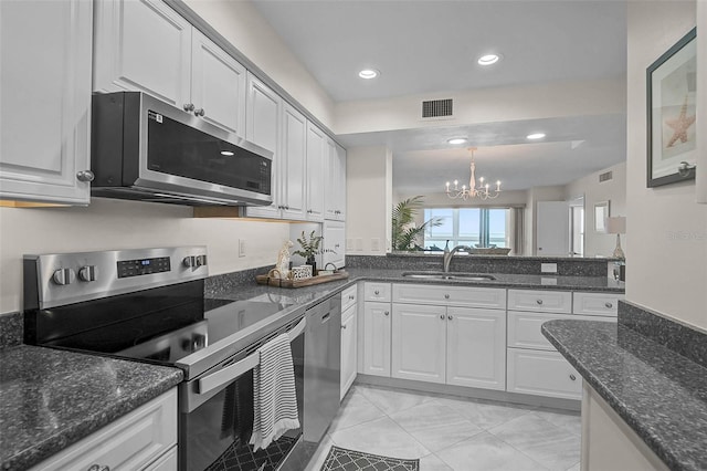 950 Tarpon Center Dr Unit 305, Venice, FL 34285 - kitchen featuring stainless steel appliances, a chandelier, white cabinetry, recessed lighting, and dark stone countertops