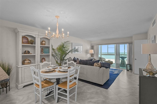 950 Tarpon Center Dr Unit 305, Venice, FL 34285 - dining room with a chandelier, a water view, light tile patterned flooring, and a textured ceiling