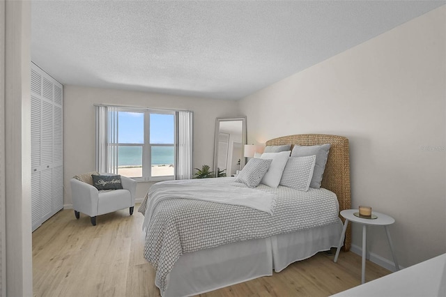 950 Tarpon Center Dr Unit 305, Venice, FL 34285 - bedroom featuring wood finished floors, a textured ceiling, and a water view