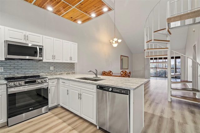 6800 Placida Rd Unit 280, Englewood, FL 34224 - kitchen with appliances with stainless steel finishes, wood ceiling, a peninsula, light wood-style floors, and high vaulted ceiling