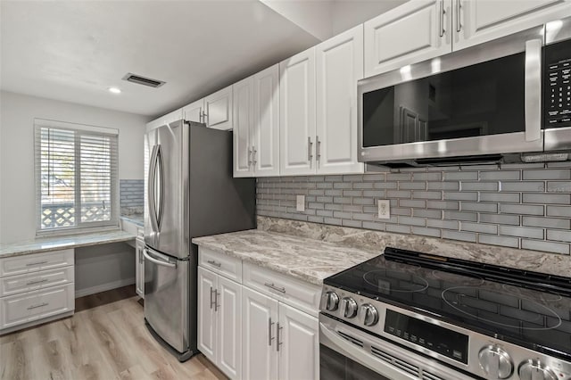 6800 Placida Rd Unit 280, Englewood, FL 34224 - kitchen featuring stainless steel appliances, white cabinetry, light wood-style flooring, and decorative backsplash