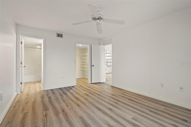 6800 Placida Rd Unit 280, Englewood, FL 34224 - unfurnished bedroom with a walk in closet, light wood-style floors, ensuite bathroom, a closet, and a ceiling fan