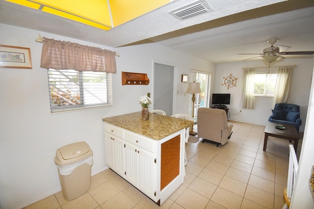 320 Base Ave E Unit 215, Venice, FL 34285 - kitchen featuring a peninsula, white cabinets, light tile patterned floors, a ceiling fan, and open floor plan