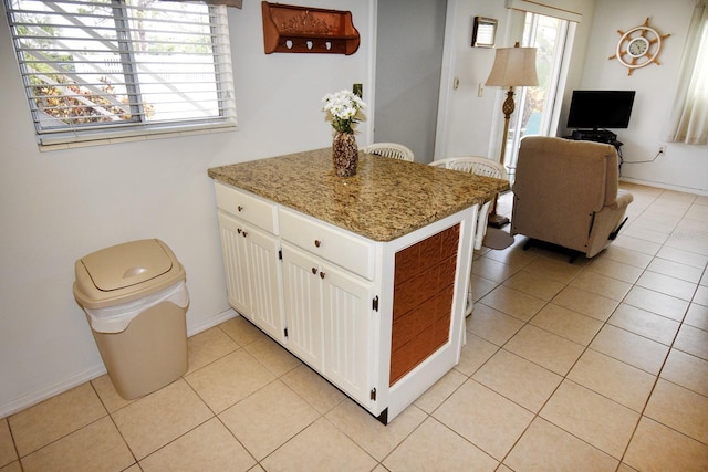 320 Base Ave E Unit 215, Venice, FL 34285 - kitchen with a peninsula, white cabinets, light tile patterned floors, and light stone countertops