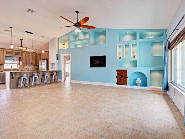 23102 Madelyn Ave, Port Charlotte, FL 33954 - unfurnished living room with a ceiling fan, light tile patterned flooring, vaulted ceiling, and built in shelves
