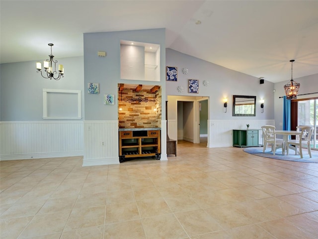 23102 Madelyn Ave, Port Charlotte, FL 33954 - living area with a chandelier, wainscoting, light tile patterned flooring, high vaulted ceiling, and a decorative wall