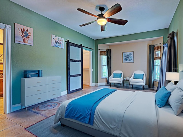 23102 Madelyn Ave, Port Charlotte, FL 33954 - bedroom featuring a barn door, a ceiling fan, and light tile patterned floors