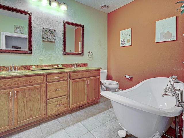 23102 Madelyn Ave, Port Charlotte, FL 33954 - bathroom with a freestanding tub, double vanity, a textured wall, tile patterned floors, and a textured ceiling