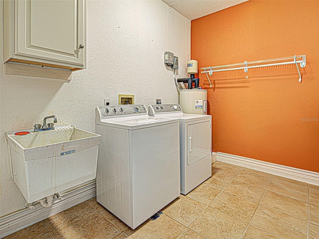 23102 Madelyn Ave, Port Charlotte, FL 33954 - washroom featuring cabinet space, a textured wall, washer and dryer, water heater, and light tile patterned floors