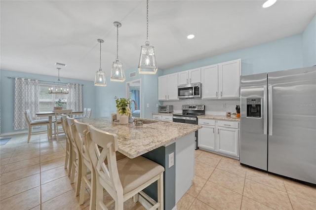 7164 Mikasa Dr, Punta Gorda, FL 33950 - kitchen with appliances with stainless steel finishes, light stone counters, light tile patterned floors, white cabinetry, and recessed lighting