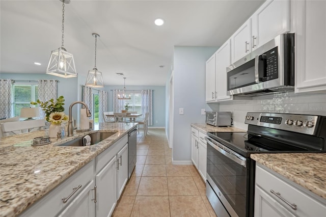 7164 Mikasa Dr, Punta Gorda, FL 33950 - kitchen with stainless steel appliances, tasteful backsplash, recessed lighting, white cabinets, and plenty of natural light