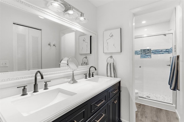 340 Three Lakes Ln Unit F, Venice, FL 34285 - full bathroom with double vanity, a shower stall, and wood finished floors