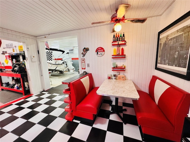 6522 Pimlico St, North Port, FL 34291 - dining room with tile patterned floors, a ceiling fan, and wooden walls