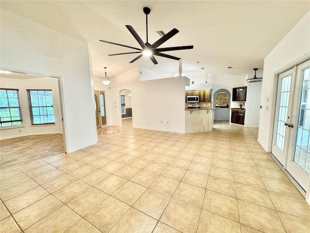 6522 Pimlico St, North Port, FL 34291 - unfurnished living room featuring arched walkways, ceiling fan, light tile patterned floors, high vaulted ceiling, and french doors